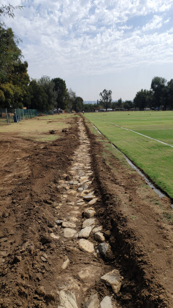 sports turf subbase preparation, artificial grass installation Gauteng, sports turf installation Randburg, sports turf installation Midrand, subbase preparation South Africa, excavation depth sports turf, stone layer sports turf, compaction standards artificial grass, drainage system sports turf, artificial grass subbase, sports field installation, crushed stone base layer, decomposed granite sports turf, vibratory plate compactor, drainage pipes artificial grass, laser leveling sports turf, edge restraints artificial turf, UV-stabilized artificial grass, clay soil drainage Gauteng, frost protection sports turf, quality control sports turf, professional sports turf installation, artificial grass foundation, sports surface drainage, perforated drainage pipes, French drains sports field, geotextile barrier, surface grading artificial grass, compaction testing, artificial grass base materials, sports turf excavation, aggregate base layer, soccer field construction, putting green installation, school soccer fields, multi-purpose sports grounds, artificial grass maintenance, sports facility drainage, highveld climate sports turf, Johannesburg artificial grass, subgrade preparation, base material testing, sports turf warranty, artificial grass cost, turf installation budget, sports surface stability, water infiltration sports turf, athletic performance surface, premium sports turf, artificial grass longevity, recreational facility turf, crushed concrete aggregate, stone base compaction, surface tolerance sports turf, grade stakes installation, screeding sports surface, perimeter drainage systems, site assessment sports turf, UV radiation protection, seasonal installation considerations, sports turf investment, facility utilization, playing surface safety, artificial grass service life, sports turf value analysis, foundation work sports turf, structural stability artificial grass, professional installation advantages, LawnKing artificial grass, Gauteng sports facilities